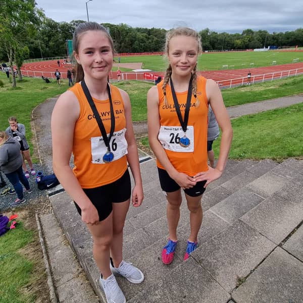 Two girls with athletics medals